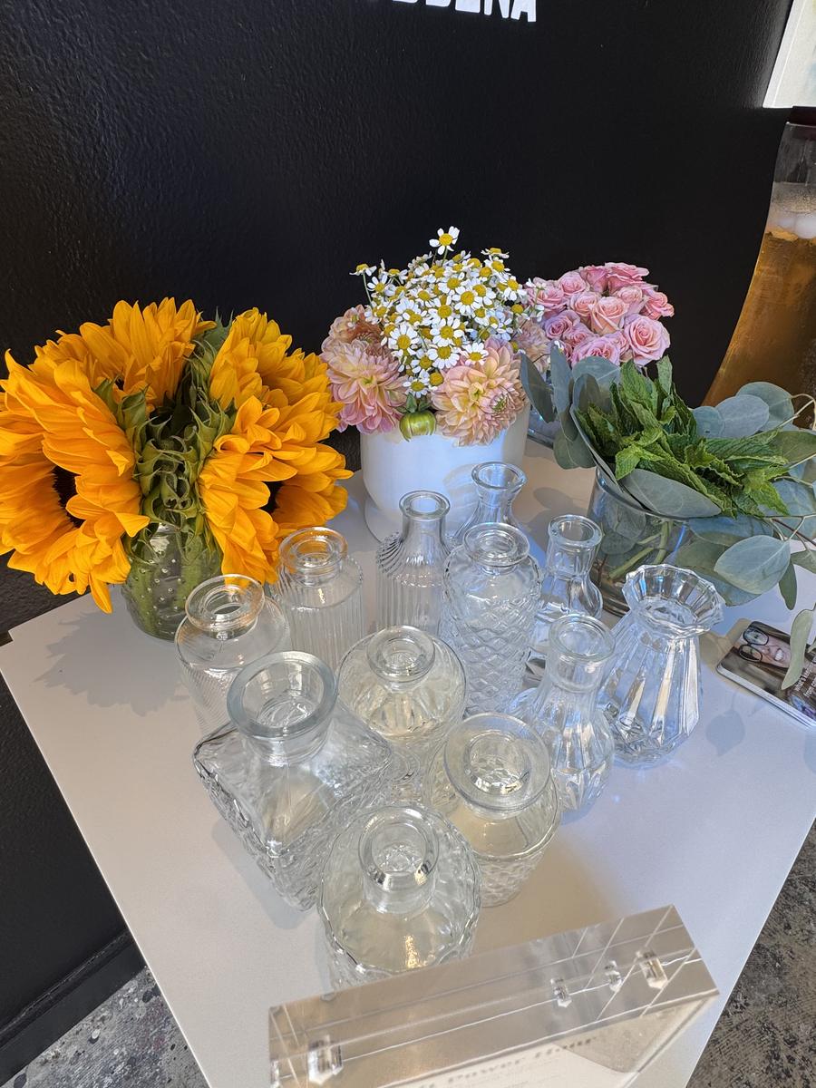Fresh flowers and glass bud vases set out for a workshop